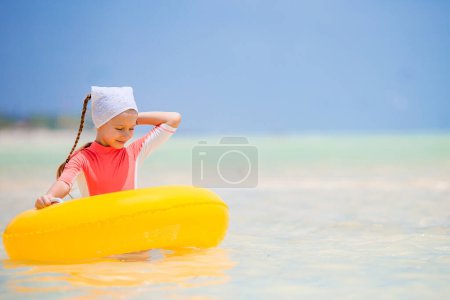 Foto de Niño feliz con el círculo inflable de goma que se divierte en la playa - Imagen libre de derechos