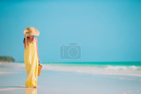 Photo for "Young beautiful woman having fun on tropical seashore. Happy girl background the blue sky and turquoise water in the sea on caribbean island" - Royalty Free Image