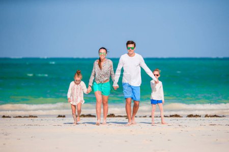 Foto de Joven familia de cuatro en vacaciones en la playa - Imagen libre de derechos
