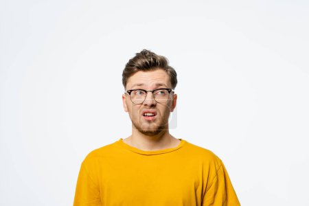 Photo for "Handsome young man in eye glasses shocked with surprise expression, fear and excited on his face.Young casual man portrait isolated on yellow background" - Royalty Free Image