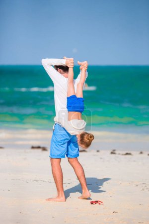 Foto de Niña y papá feliz divirtiéndose durante las vacaciones en la playa - Imagen libre de derechos