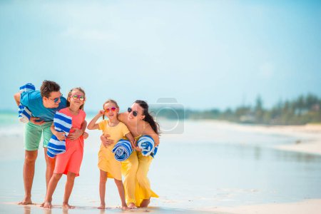 Téléchargez les photos : Joyeux famille de quatre personnes sur la plage - en image libre de droit