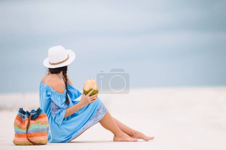 Téléchargez les photos : Femme allongée sur la plage profitant de vacances d'été regardant la mer - en image libre de droit