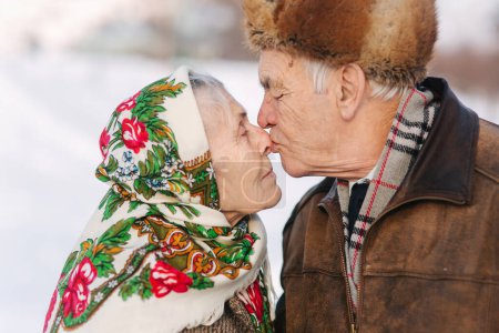 Téléchargez les photos : Portrait d'heureux couple de personnes âgées. Femme âgée embrasser son mari dans le poids. vieux couple marchant dans le parc en hiver. Bonne famille. Mariage d'or - en image libre de droit