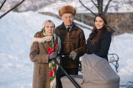 Photo for Grand Grandparents walking with a baby in beautiful pram. Winter time - Royalty Free Image
