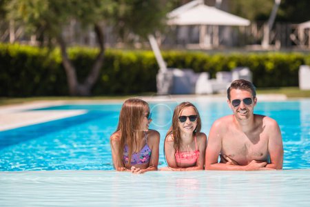 Téléchargez les photos : Heureuse famille de trois personnes en piscine extérieure - en image libre de droit