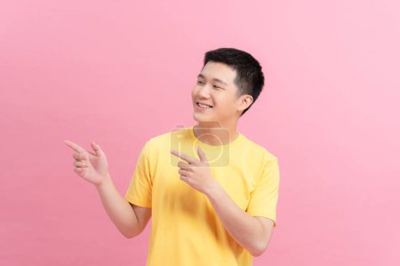 Téléchargez les photos : Asian a man handsome young pointing with two hands and fingers to the side on pink background - en image libre de droit
