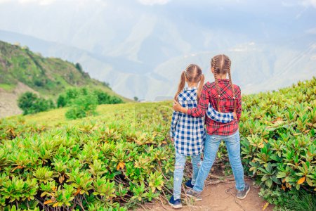 Téléchargez les photos : Belles petites filles heureuses dans les montagnes dans le fond de brouillard - en image libre de droit