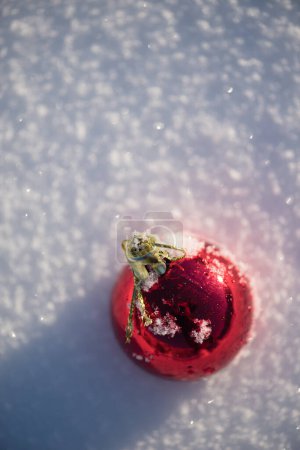 Foto de Bola roja de Navidad en nieve fresca. Concepto vacaciones de invierno - Imagen libre de derechos