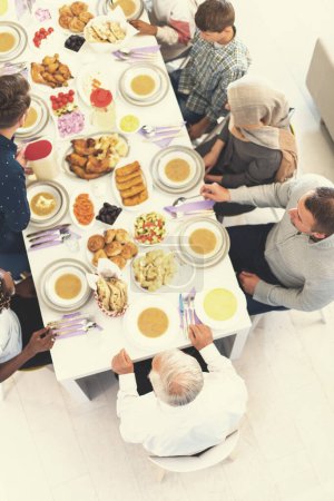 Foto de Vista superior de la familia musulmana multiétnica moderna a la espera del comienzo de la cena iftar - Imagen libre de derechos