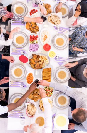 Téléchargez les photos : Vue de dessus de la famille musulmane multiethnique moderne ayant une fête du Ramadan - en image libre de droit