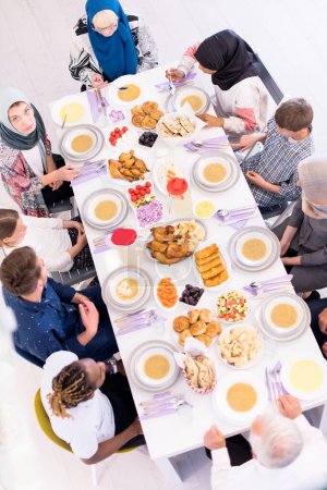 Foto de Vista superior de la familia musulmana multiétnica moderna a la espera del comienzo de la cena iftar - Imagen libre de derechos