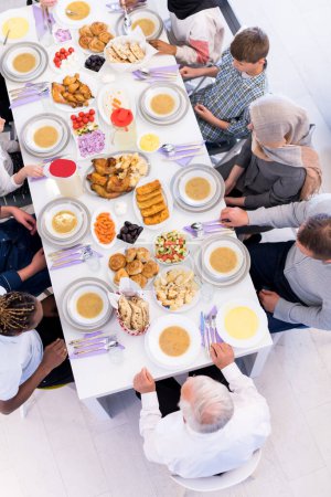 Téléchargez les photos : Vue du sommet de la famille musulmane multiethnique moderne attendant le début du dîner iftar - en image libre de droit