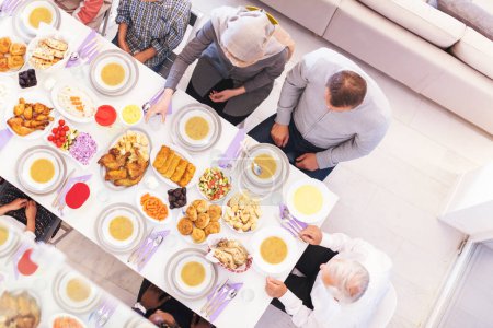 Photo for Top view of modern multiethnic muslim family waiting for the beginning of iftar dinner - Royalty Free Image