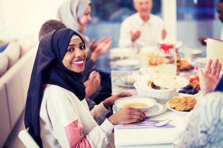 Photo for Black modern muslim woman enjoying iftar dinner with family - Royalty Free Image