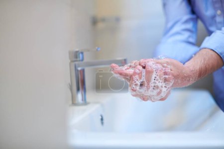 Téléchargez les photos : Coronavirus male wahing hands in bathroom - en image libre de droit