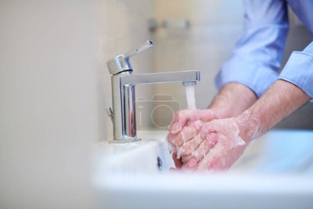 Photo for Coronavirus male wahing hands in bathroom - Royalty Free Image