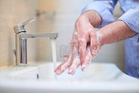 Photo for Coronavirus male wahing hands in bathroom - Royalty Free Image