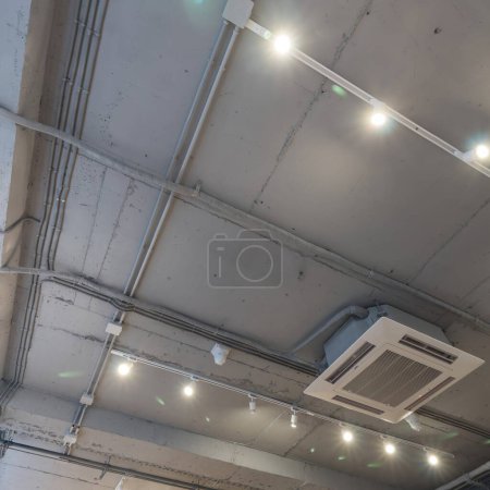 Foto de "Abstracto loft interior de hormigón gris techo con ventilación de aire y cámara de seguridad. Arquitectura interior y diseño de techo del edificio loft industrial decorado con lámparas modernas" - Imagen libre de derechos