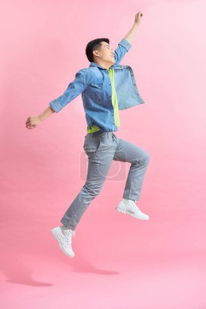 Foto de Sonriente joven saltando en el aire - Imagen libre de derechos