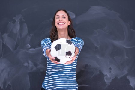 Photo for Woman holding a soccer ball in front of chalk drawing board - Royalty Free Image