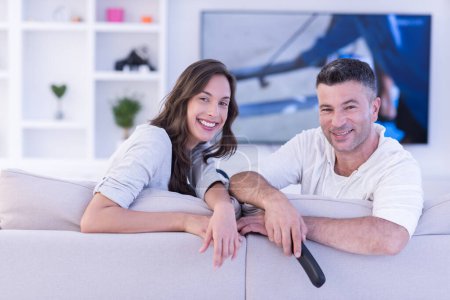 Photo for Young couple on the sofa watching television top view - Royalty Free Image