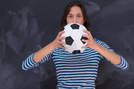 Foto de Mujer sosteniendo una pelota de fútbol delante de la pizarra de dibujo - Imagen libre de derechos