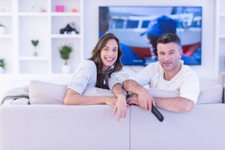 Téléchargez les photos : Jeune couple sur le canapé regarder la télévision vue du dessus - en image libre de droit