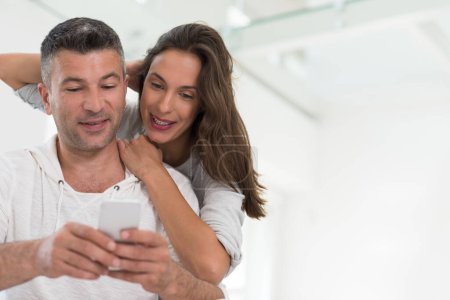 Photo for "happy couple using mobile phone at home" - Royalty Free Image