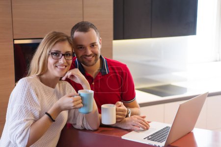 Foto de "pareja beber café y el uso de la computadora portátil en casa
" - Imagen libre de derechos