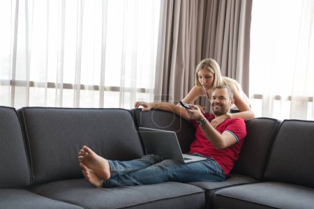 Photo for "happy couple relaxes in the living room" - Royalty Free Image