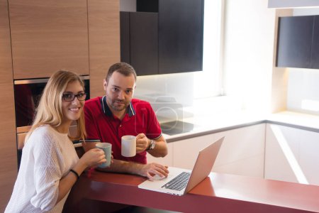 Photo for "couple drinking coffee and using laptop at home" - Royalty Free Image