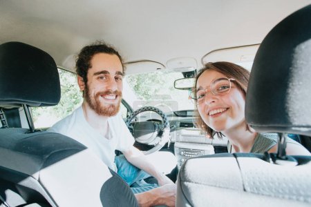 Téléchargez les photos : Young hipster couple using a map on a road trip for directions. Reading a map. Cheerful loving couple relaxing on vacation. Trip on route vacation. Happy and smiling to camera. Decision taking - en image libre de droit