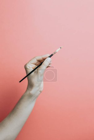 Foto de Brush in hand. Isolated on soft background. Painting positions removable background - Imagen libre de derechos