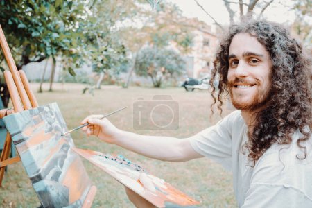 Photo for Portrait of Artist Working. Close-up Shot portrait, long hair young man painting oil - Royalty Free Image
