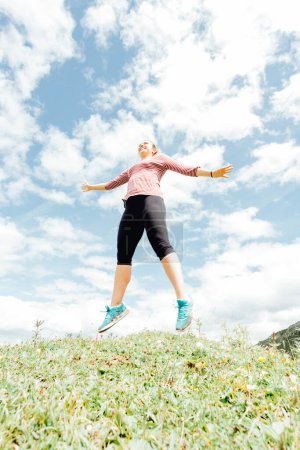 Photo for Lifestyle woman jumping in freedom exercise and pose for healthy life. Young girl or people pose balance body vital zen and meditation for workout nature mountain background. Copy space for banner. - Royalty Free Image