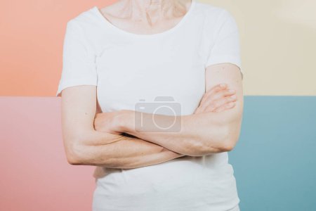 Téléchargez les photos : "Old woman standing over isolated and smiling colorful background. Young woman dressed in white t-shirt, blank space t shirt copy space, design, shopping commercial shot" - en image libre de droit