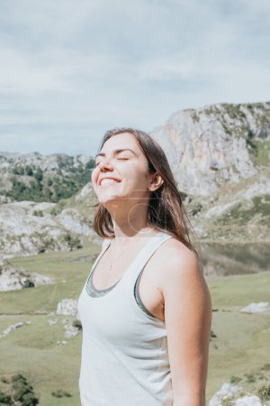 Photo for Portrait of young smiling woman face in windy day standing at mountain - carefree woman.happy traveler hipster girl with windy hair smiling, top of mountains. space for text. atmospheric moment. - Royalty Free Image