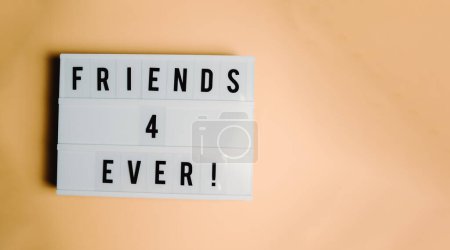 Photo for White sign over a pastel orange background, friendship meaning, care and love concepts - Royalty Free Image