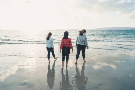 Téléchargez les photos : Bonnes jeunes femmes riant et souriant à la plage un jour d'été, profitant de vacances, concept d'amitié profiter de l'extérieur - en image libre de droit