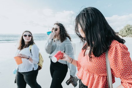 Foto de Mujeres jóvenes felices riendo y sonriendo en la playa en un día de verano, disfrutando de vacaciones, concepto de amistad disfrutando del aire libre - Imagen libre de derechos