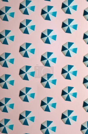 Téléchargez les photos : Pattern of blue umbrellas over a pastel pink background, minimalism, design and digital resource, background with copy space - en image libre de droit