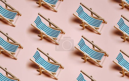 Téléchargez les photos : Pattern of summer beach chairs over a pastel pink background with copy space, minimalism, summer and relax concept, networks - en image libre de droit