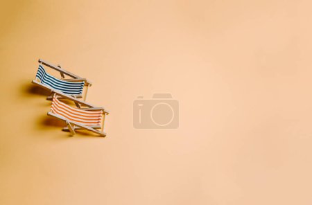 Foto de Pair of summer beach chair over a pastel yellow background with copy space, minimalism, summer and relax concept, networks - Imagen libre de derechos
