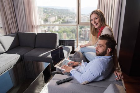 Téléchargez les photos : "couple se détendre à la maison en utilisant des ordinateurs portables
" - en image libre de droit