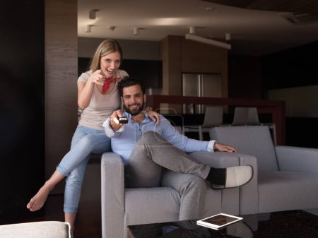 Photo for Young couple on the sofa watching television top view - Royalty Free Image