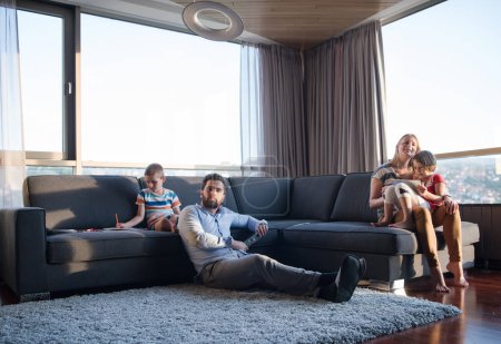 Téléchargez les photos : Joyeux jeune famille jouant ensemble sur le canapé - en image libre de droit