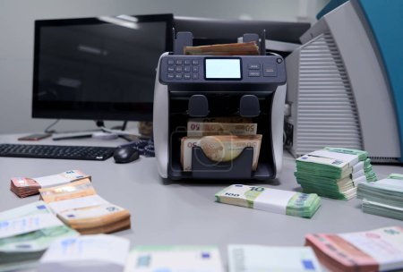 Foto de Billetes frente a la máquina contadora de dinero electrónico - Imagen libre de derechos