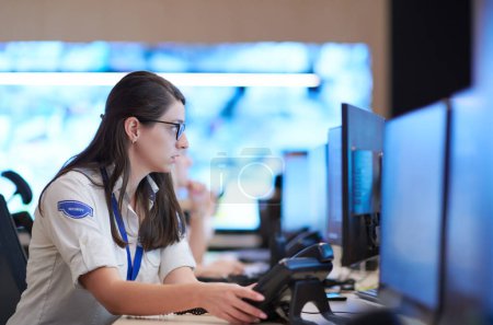 Photo for Female operator working in a security data system control room - Royalty Free Image