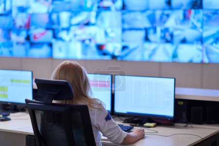 Téléchargez les photos : Opérateur féminin travaillant dans une salle de contrôle du système de données de sécurité - en image libre de droit
